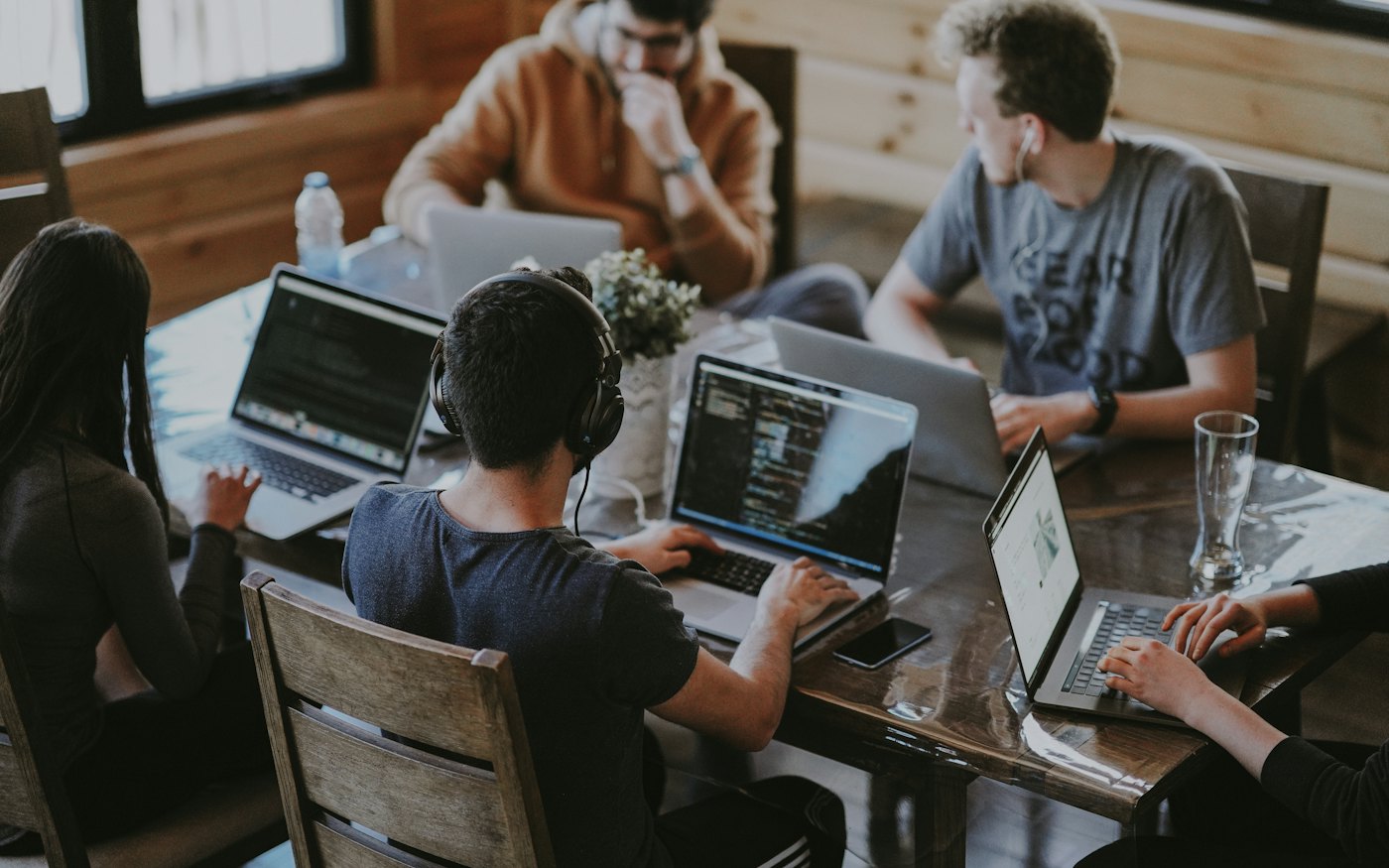 Engineers collaborating around laptops